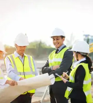 ヘルメットと安全ベストを着けて工事現場に立つ人のイメージ写真